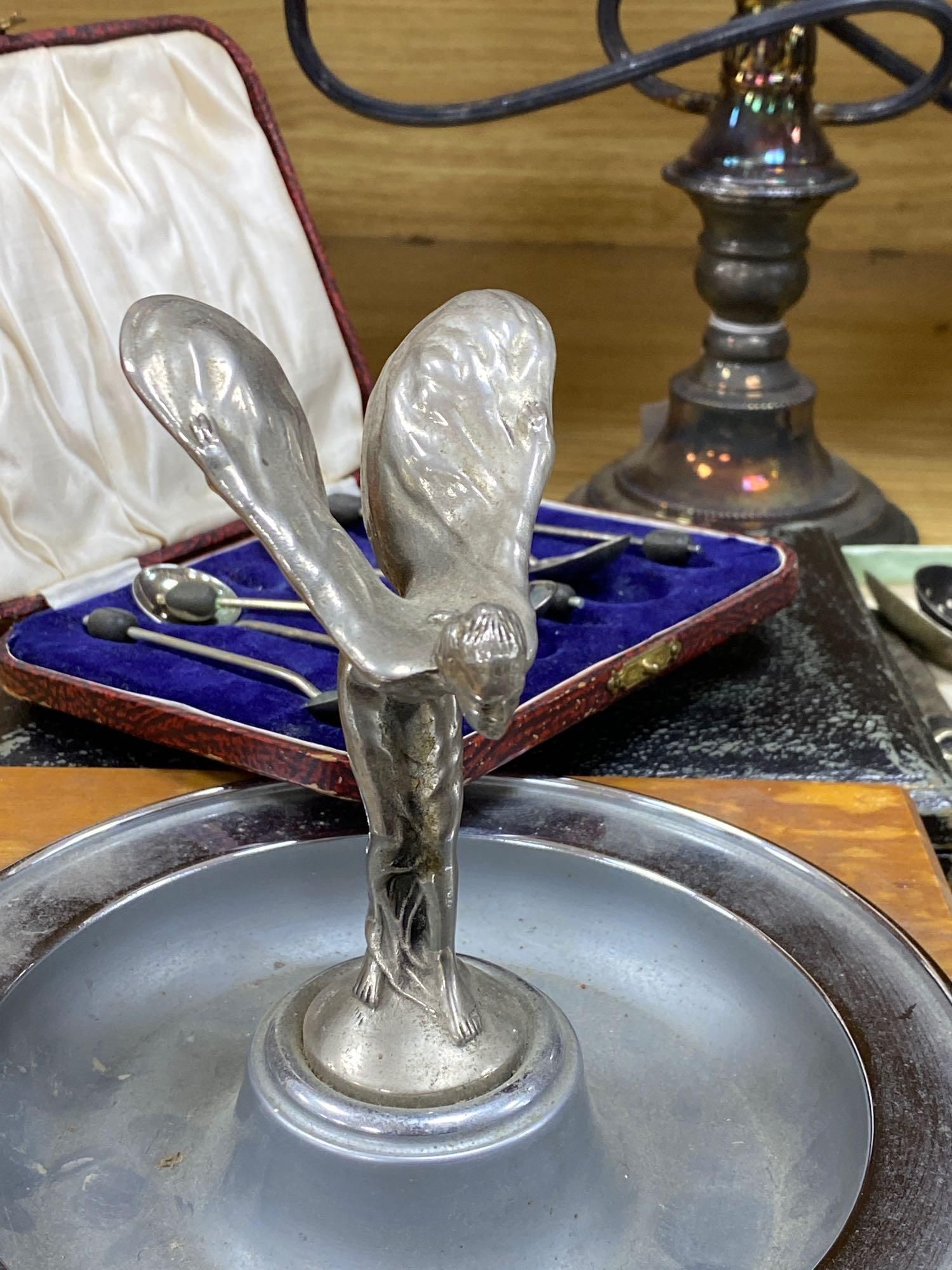 A plated cocktail shaker with recipes, a chrome Spirit of Ecstasy style car mascot on metal base and wood plinth and sundries,